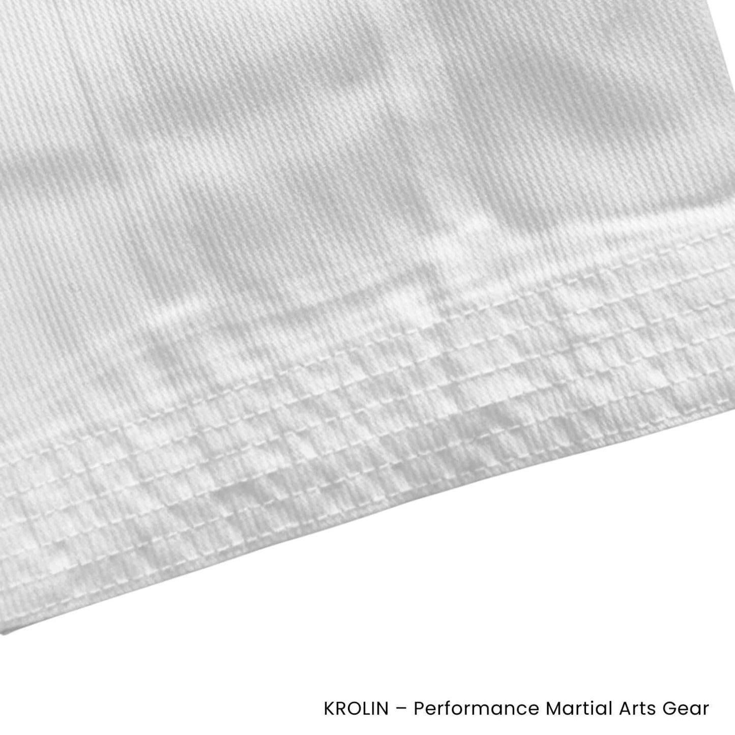 Close-up of a white martial arts uniform fabric with 'Krolin' branding.