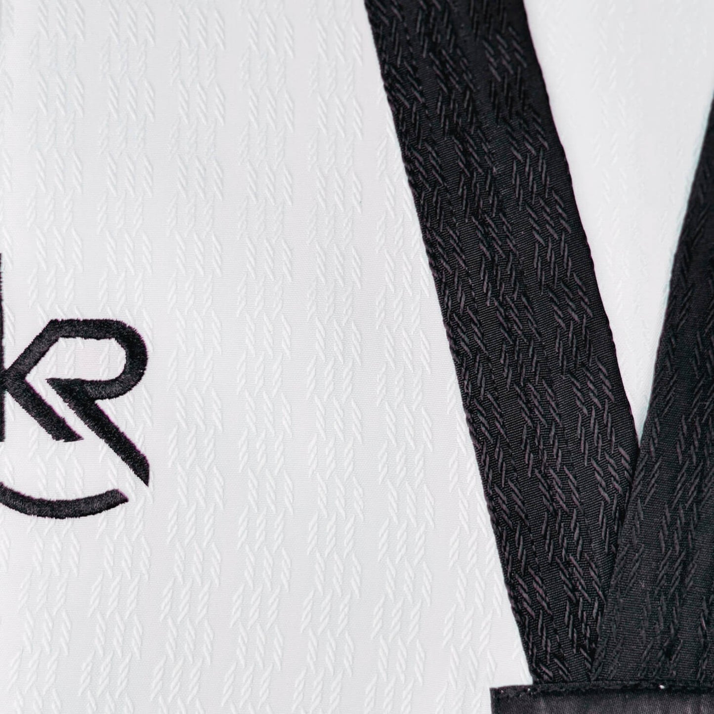 Close-up of a black textured belt with a white background featuring a logo -breathable and durable for high performance. 