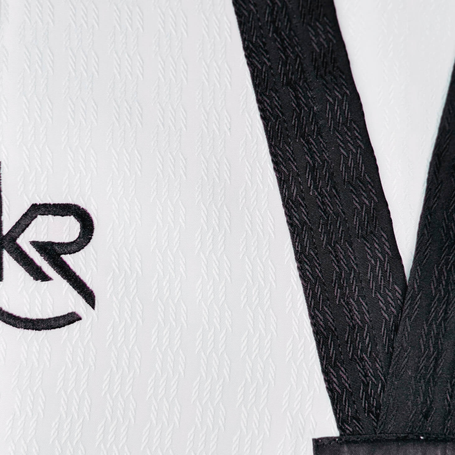 Close-up of a black textured belt with a white background featuring a logo -breathable and durable for high performance. 