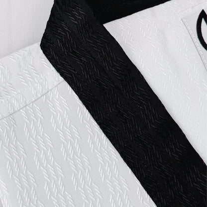 Close-up of a white martial arts uniform with a black belt on a light gray background- breathable and durable for high performance. 